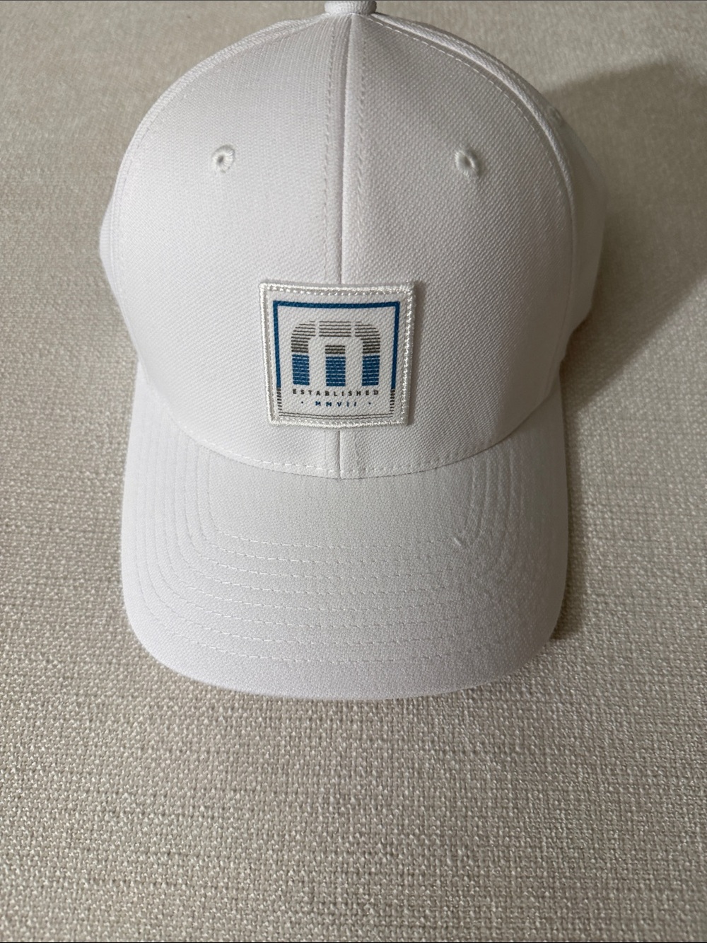 NWOT Travis Mathew White Cap with Blue Logo Patch